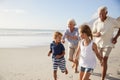 Grandparents Running Along Beach With Grandchildren On Summer Vacation Royalty Free Stock Photo