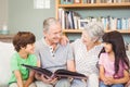 Grandparents showing album to grandchildren