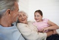 Grandparents Sitting With Granddaughter On Couch Royalty Free Stock Photo