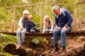 Grandparents sitting with grandkids on a bridge in a forest Royalty Free Stock Photo