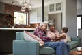 Grandparents Sitting On Sofa With Baby Granddaughter At Home Royalty Free Stock Photo