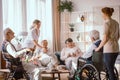 Grandparents spending time in common room with their caregivers Royalty Free Stock Photo