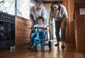 Grandparents, teaching child to ride and bike in kitchen, home or childhood memory of learning with elderly people. Kid Royalty Free Stock Photo