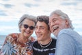 Grandparents with teenage boy grandson hugging each other at the sea having fun together and smiling happily Royalty Free Stock Photo
