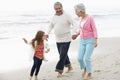 Grandparents Walking Along Beach With Granddaughter Royalty Free Stock Photo