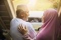 Grandparents waving at their grandchildren in the car