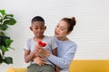 Grandson child congratulates grandmother on holiday and gives a heart shape, Grandmother and grandson playing cheerfully in living Royalty Free Stock Photo