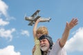 Grandson child and grandfather having fun with toy plane on sky. Child dreams of flying, happy childhood with granddad. Royalty Free Stock Photo