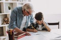 Grandson Doing School Homework with Old Man Home Royalty Free Stock Photo