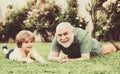 Grandson embrace his grandfather. Happy family father and child on meadow with a kite in the summer on green grass. Cute Royalty Free Stock Photo