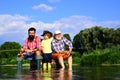 Grandson with father and grandfather fishing by lake. Father, son and grandfather on fishing trip. Family bonding Royalty Free Stock Photo