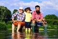 Grandson with father and grandfather fishing by lake. Father, son and grandfather on fishing trip. Family bonding Royalty Free Stock Photo