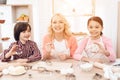 Grandson and granddaughter together with happy grandmother are engaged in cooking in kitchen. Royalty Free Stock Photo