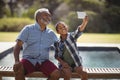 Grandson and grandfather taking selfie with mobile phone Royalty Free Stock Photo