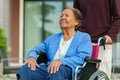 Grandson pushing senior woman in wheelchair at outside house Royalty Free Stock Photo