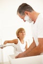 Grandson Watching Grandfather Shaving In Bathroom