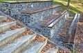 Grandstand in the park by a concrete staircase made of gabion baskets with gray stones arranged inside. the seating areas of the b