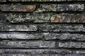 Gray granite wall, reddish stones, cement and moos