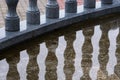 The granite balustrade is reflected in a puddle. Royalty Free Stock Photo