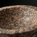 Granite bowl featuring a speckled pattern of rust-colored and black minerals. The Royalty Free Stock Photo