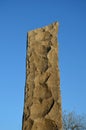 The granite column is stone-beaten with coarse chips reminiscent of the prehistoric production of spears from siliceous obsidians. Royalty Free Stock Photo