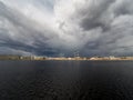 Granite embankment of the river with storm clouds over the water