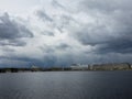 Granite embankment of the river with storm clouds over the water Royalty Free Stock Photo