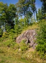 Exposed Large Granite Stone on Hillside Tree Covered Hill Royalty Free Stock Photo