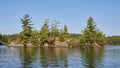 Granite Island with trees in a Muskoka lake Royalty Free Stock Photo