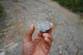 A geologist`s hand is holding a piece of granite rock.