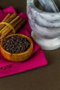 Black peppercorns, cinnamon sticks, pestle and mortar Royalty Free Stock Photo