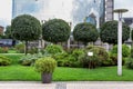 Granite pot with an evergreen bush on a pedestrian sidewalk made of stone. Royalty Free Stock Photo