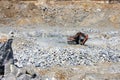 Granite quarry. Mining industry. Large crawler orange excavator with bucket Royalty Free Stock Photo