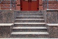 Granite staircase with a rise to the front door.