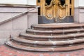 Granite staircase with a rise to the wooden entrance door.