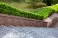 Granite staircase with stone steps in a park with trimmed boxwood bushes. Royalty Free Stock Photo