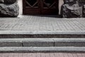 Granite steps on a pedestrian pavement made of stone tiles near a building with entrance. Royalty Free Stock Photo