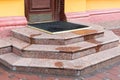 Granite steps of a stone threshold with a rubber foot mat. Royalty Free Stock Photo