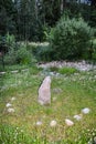 Granite stone sundial on willow bush lawn Royalty Free Stock Photo