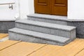 Granite threshold at the entrance door made of brown wood and white facade. Royalty Free Stock Photo