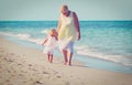 granmother with little granddaughter walk on beach Royalty Free Stock Photo