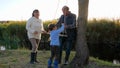 Grannie with grandfather doing swing on tree for child outdoors in vivid sunlight