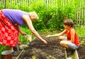 Grannie with grandson work in the summer garden