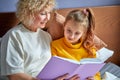 Granny and daughter read a book before bed. Evening ritual before bedtime Royalty Free Stock Photo