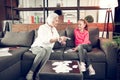 Granny and girl sitting on sofa and studying using flashcards
