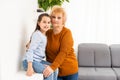 Granny and granddaughter are using a laptop and smiling while sitting on sofa at home Royalty Free Stock Photo