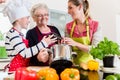 Granny, mum and son talking while cooking in kitchen Royalty Free Stock Photo