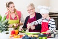 Granny, mum and son talking while cooking in kitchen Royalty Free Stock Photo