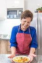 Granny smiling serving soup in the kitchen