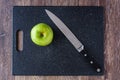 Granny Smith apple on a black cutting board with a chef knife, ready to slice Royalty Free Stock Photo